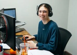 Smiling young woman in blue sweatshirt with headphones on