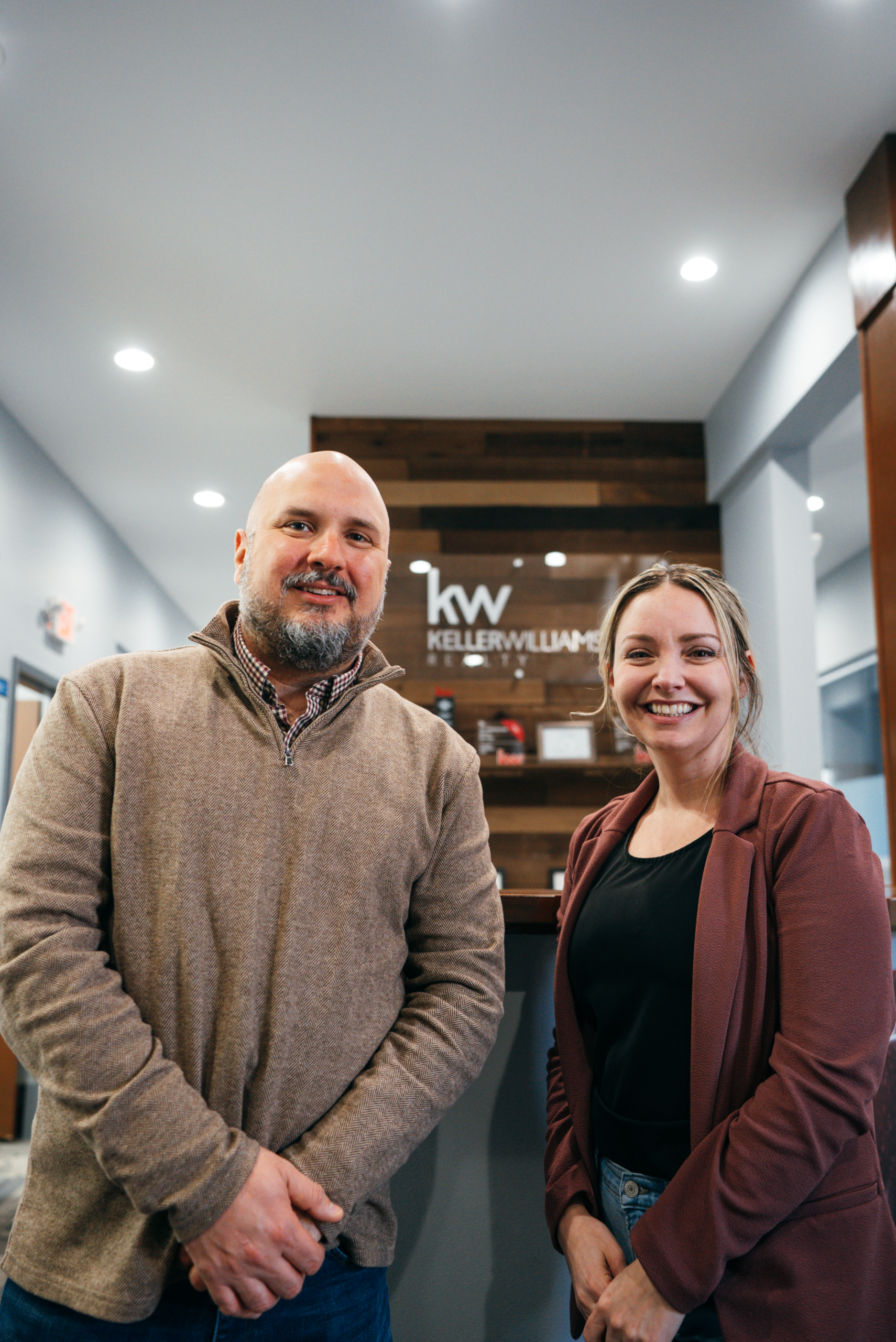 A man and woman smiling at a Keller Williams office