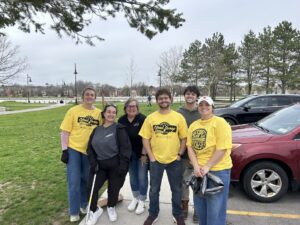 Group of people wearing yellow t-shirts standing outdoors.