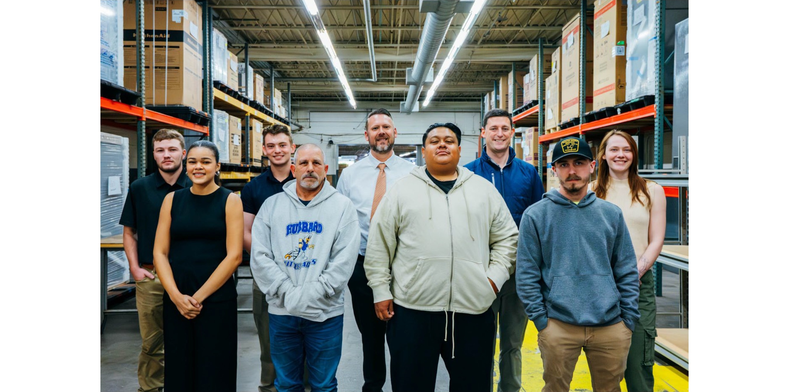 A diverse group of adults in casual clothing standing together