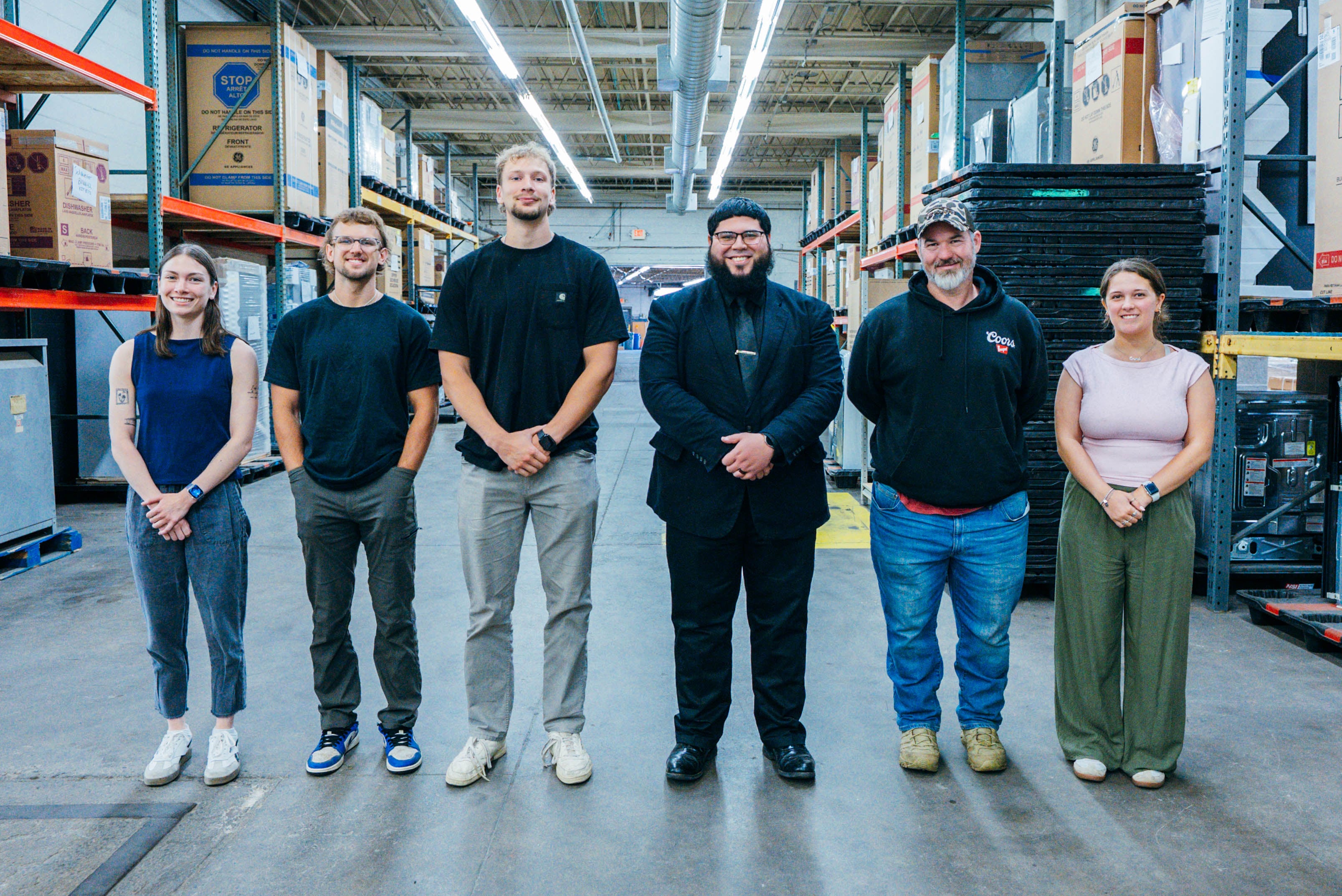 A group of people standing in a warehouse together