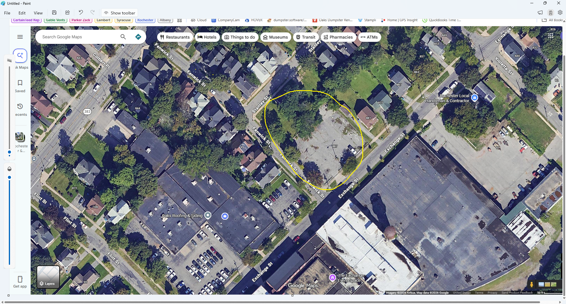 Overhead view of a neighborhood with houses, parking lots, and marked areas.