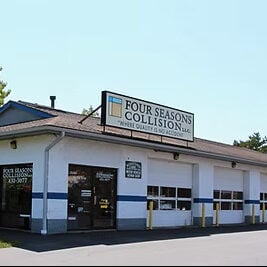 An abandoned building with snow on the roof. The building appears to be old and neglected.